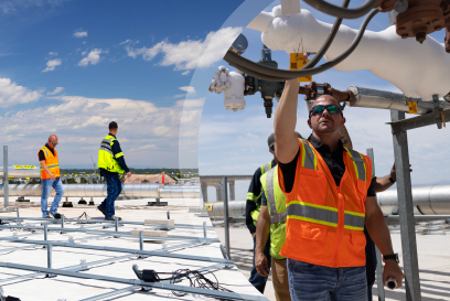 Energy professionals conducting an on-site evaluation with solar panel installation in the background, reflecting Lineage's active role in sustainable energy management and carbon reduction.