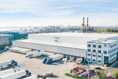 A large Lineage cold storage warehouse in New Jersey, with the Lineage logo, featuring multiple loading docks with trucks, located in an industrial area with proximity to a port.