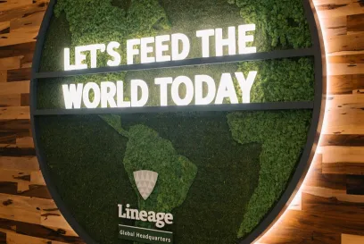 A green map of the world with signage that reads "Let's Feed the World Today" at Lineage Global Headquarters
