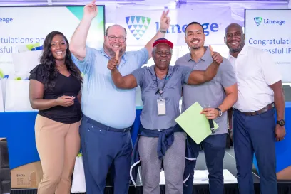 A group of Lineage team members celebrate the company's successful IPO with smiles and thumbs up at a Starting LINE party
