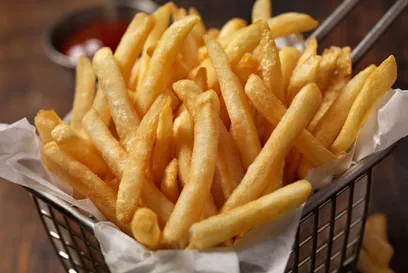 Golden, crispy French fries served in a basket, ready to eat, highlighting the end of the frozen French fry supply chain and foodservice delivery.