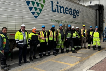 Miembros del equipo de almacén de Calgary Great Plains juntos delante de un remolque de Lineage , mostrando una sólida cultura de seguridad y unidad de equipo.