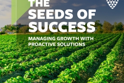 Green crop field under a clear sky with bold text reading “The Seeds of Success: Managing growth with proactive solutions.”