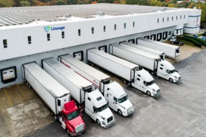 Lineage temperature-controlled warehouse with trucks loading at dock doors for cross-border logistics operations