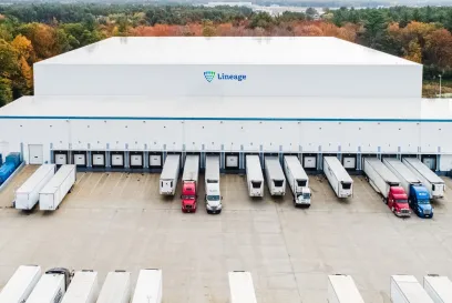 Aerial view of a Lineage cold storage warehouse with multiple semi-trailers at loading docks, supporting managed transportation and integrated cold chain logistics.