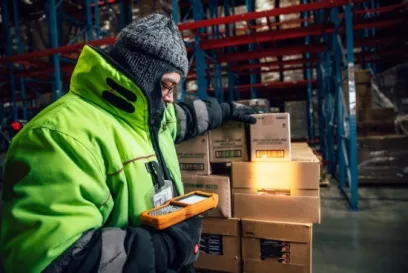 Lineage team member scans cases of food products inside a temperature-controlled warehouse to support inventory tracking and food traceability.