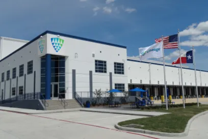 Lineage cold storage facility in Dallas-Fort Worth with loading docks and American and Texas flags outside the building.