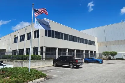 Vue extérieure de LineageDignan à Jacksonville, en Floride, mettant en valeur la conception moderne du bâtiment et les drapeaux bien en vue sous un ciel bleu clair.