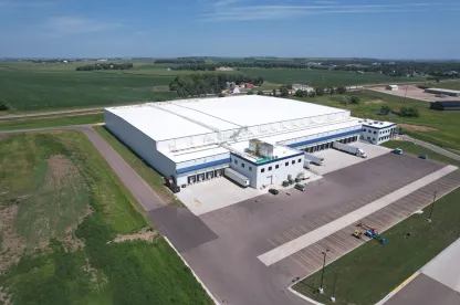 Vue aérienne de LineageL’entrepôt frigorifique de Luverne au Minnesota, comprenant plusieurs quais de chargement, des remorques stationnées et de vastes terres agricoles environnantes, soulignant son emplacement stratégique pour les opérations de la chaîne du froid.