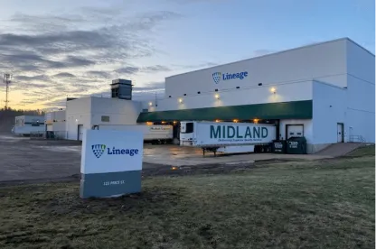 El almacén frigorífico de Lineage en Moncton, 123 Price Street, New Brunswick, con la señalización de la empresa, los muelles de carga y los remolques aparcados bajo el cielo de primera hora de la mañana.
