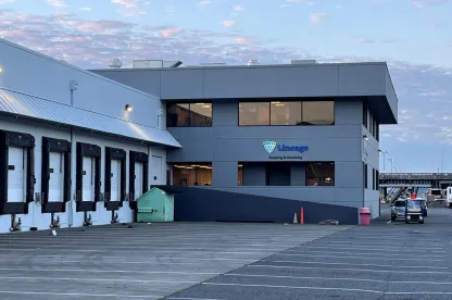 Instalaciones de Lineage Seattle-Garfield con una vista de los muelles de carga y el cartel de "Shipping & Receiving" bajo un cielo matutino.