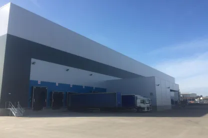 Moderno almacén frigorífico a temperatura ambiente con múltiples muelles de carga y remolques en las instalaciones de Lineageen Belle Eau Park, Bilsthorpe, Reino Unido.