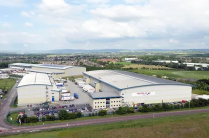 Vista aérea del almacén frigorífico automatizado de Lineageen Heywood, Reino Unido, con camiones de Yearsley Group y múltiples edificios en un gran recinto logístico.