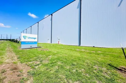 Extérieur de Lineageà Houston, Texas, montrant le grand mur blanc de l’entrepôt et le Lineage Panneau le long de la pelouse herbeuse avant par temps clair.