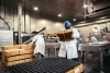 Workers in a food processing facility carrying boxes